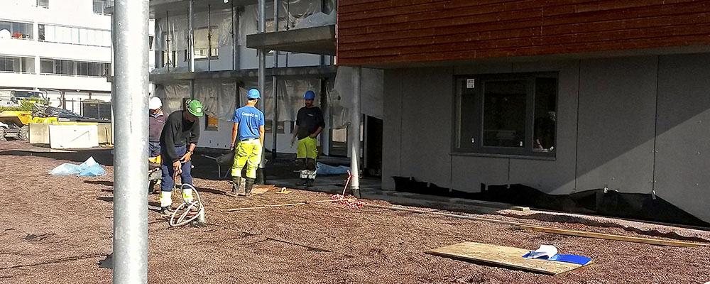 Drenering av takterrasser - Anleggsarbeidere ved byggeplass